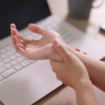 Person holding their wrist to illustrate symptoms associated with carpal tunnel syndrome.