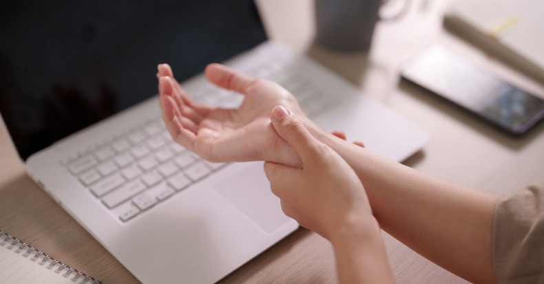Person holding their wrist to illustrate symptoms associated with carpal tunnel syndrome.