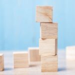Stacked wooden blocks representing balance, stability, and structural support